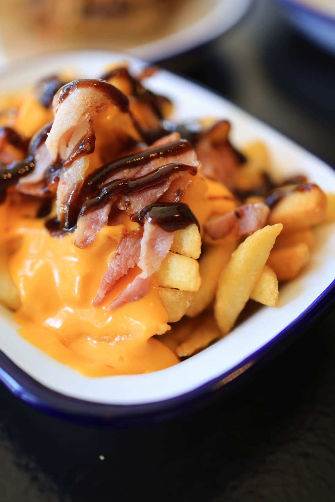 Loaded cheese fries topped with creamy cheese sauce and smoky meat strips.